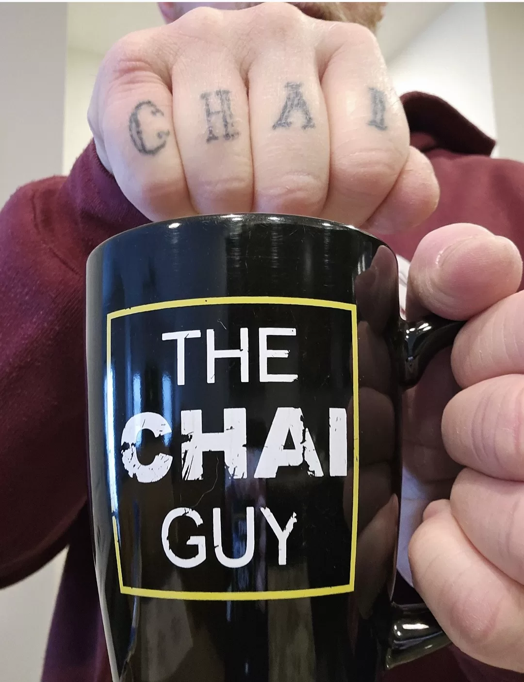 Pat Tharp raising a Chai Guy mug